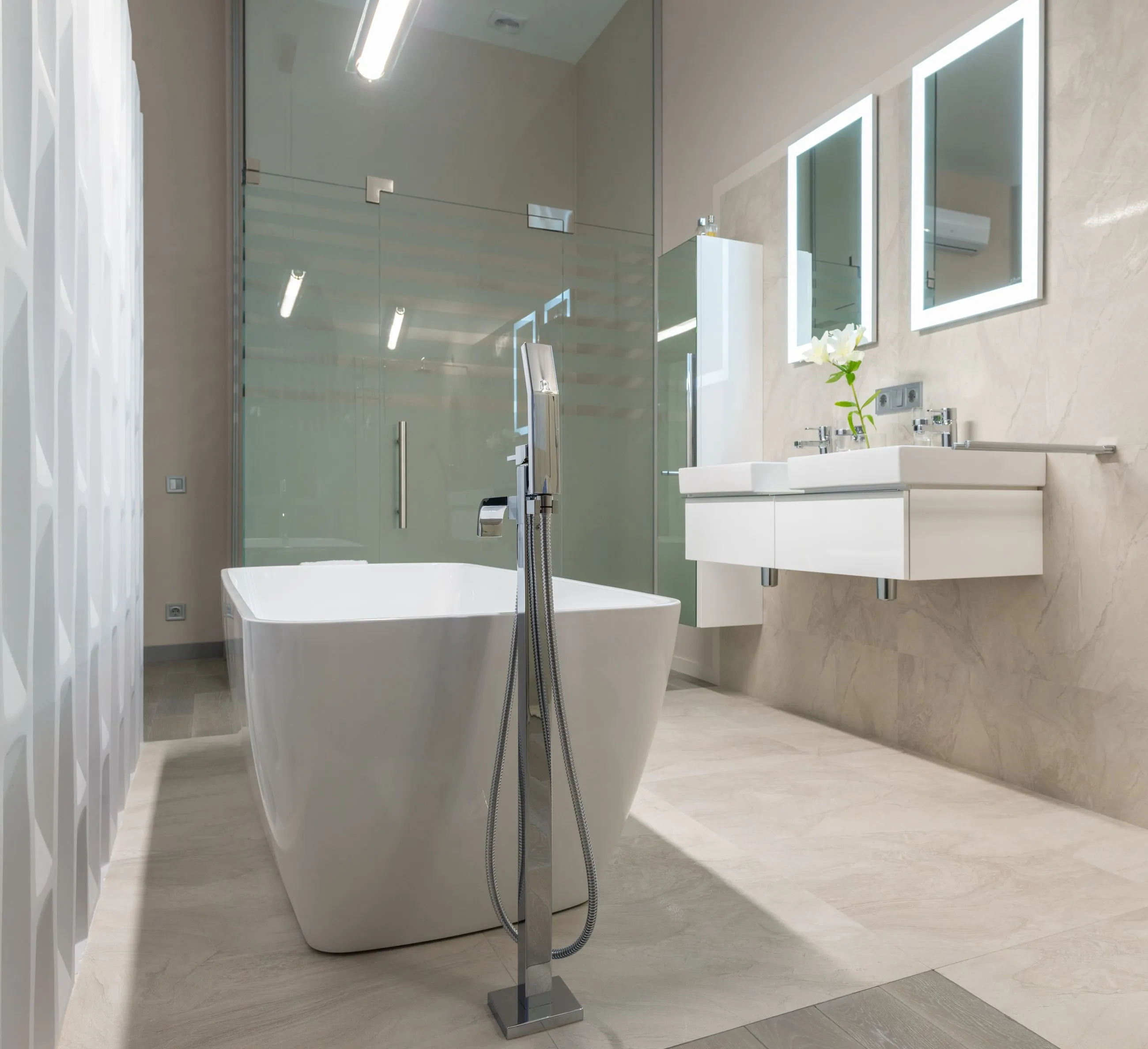 Baño amplio con bañera exenta, mampara de vidrio y doble lavabo