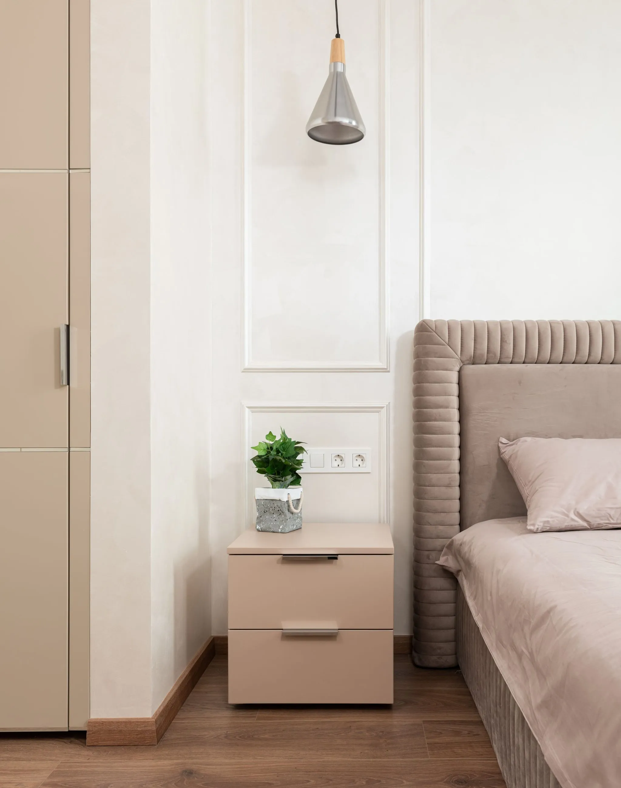 Detalle de dormitorio en tonos beige con textiles y madera