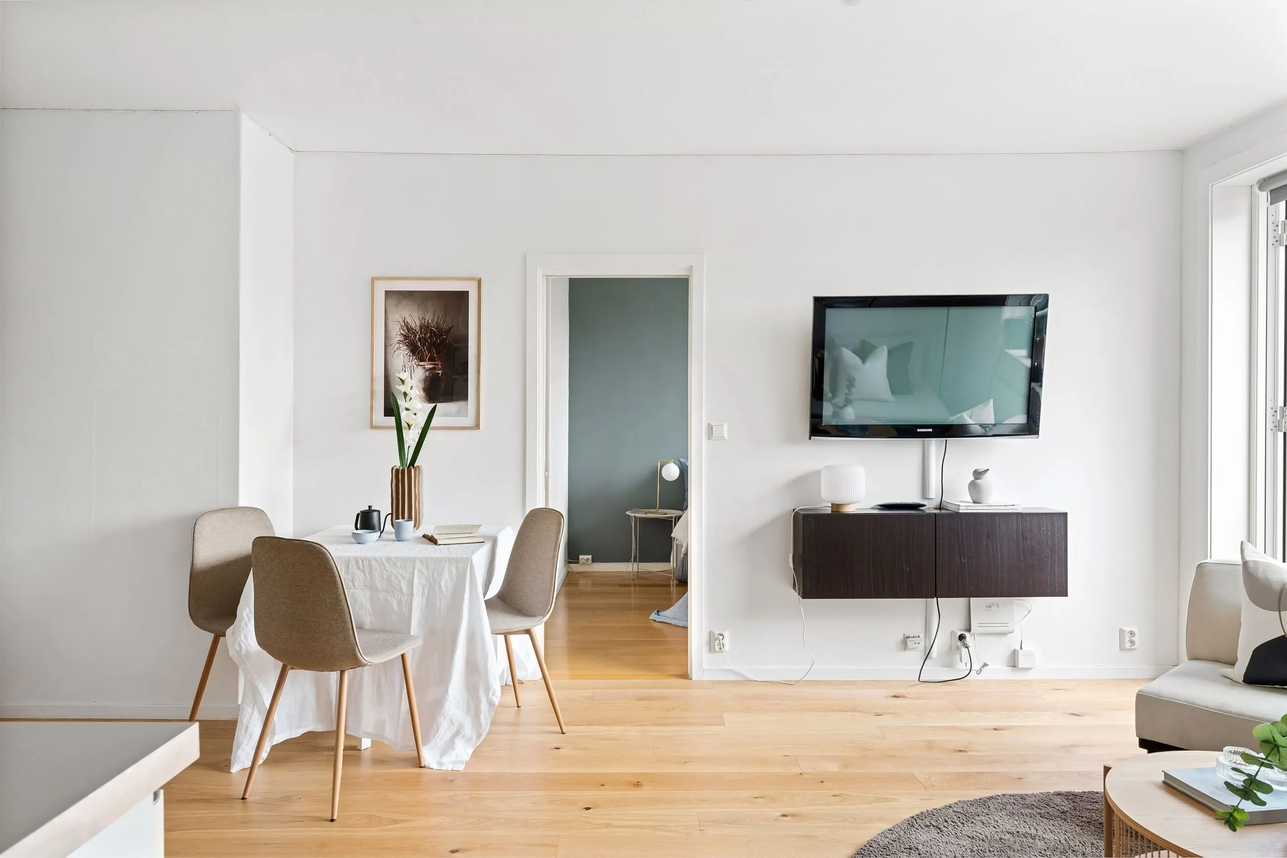 Salón-comedor con suelo de madera y mesa redonda